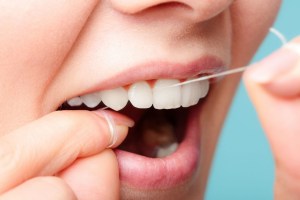 A woman Flossing her teeth